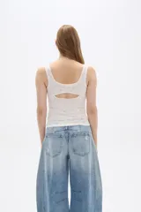 Top sin mangas confeccionado en algodón con diseño de broderie, corte al cuerpo y escote redondo con detalle de puntilla en los bordes.