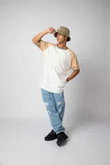 Remera estilo raglán color blanco en el cuerpo, con mangas en tono tostado y ribetes en color verde militar en el cuello y los puños.
