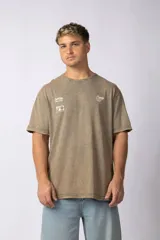 Remera de algodón con efecto lavado, color marrón, de corte holgado y manga corta. Presenta pequeños estampados gráficos en el pecho.