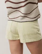 Short gris claro de tiro alto con costuras pespunteadas en contraste y bolsillos traseros amplios. Presenta una etiqueta de cuero rojo en la parte posterior de la cintura.