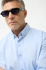 Camisa de vestir azul con cuello abotonado, corte clásico y mangas largas.