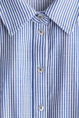 Vestido midi con diseño a rayas en tonos azul y blanco, cuello camisero, botonadura frontal y mangas raglán cortas. Cuenta con elástico fino en la parte posterior de la cintura y tira para atar extraíble.