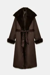 Abrigo largo de Zara Woman Collection en color marrón chocolate, con cuello de solapa amplio, mangas largas y cinturón ajustable del mismo tejido. Presenta detalles de forro interior y acabados en efecto pelo a tono en cuello, puños y bordes frontales.