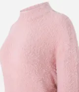 Suéter de punto color crema con cuello redondo y mangas largas ajustadas. Modelo slim alargado con efecto de pelitos.