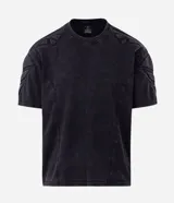 Remera boxy de algodón color negro con efecto desteñido, cuello redondo, mangas cortas y hombreras estructuradas con recortes y pespuntes.