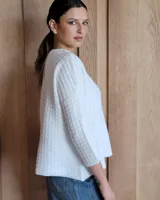 Sweater de punto color verde claro con textura tipo waffle, cuello redondo y mangas 3/4.