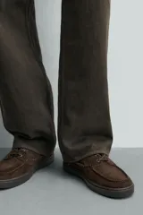 Mocasines estilo náutico de piel con acabado serraje, en color tostado, con cordones y suela de goma a contraste.