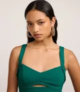 Top cropped de color verde esmeralda, confeccionado en bengalina de viscosa certificada. Presenta escote corazón con un detalle de abertura en el busto y breteles anchos.
