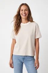Remera básica de corte holgado, color beige melange, de manga corta y cuello redondo acanalado.