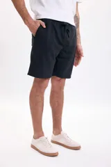Bermuda deportiva negra de corte recto, con cintura elástica y cordón ajustable del mismo tono. Cuenta con bolsillos laterales.
