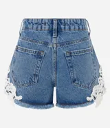 Short de jean tiro medio con encaje floral blanco aplastado en los laterales y dobladillo deshilachado. Cuenta con bolsillos delanteros y traseros, pasacintos y cierre frontal con botón y cremallera.