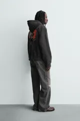 Sudadera con capucha de corte relajado y efecto lavado, confeccionada en mezcla de algodón con interior afelpado. Presenta manga larga, puños y bajo en rib, bolsillo frontal tipo canguro y estampado gráfico de Post Malone en el pecho.