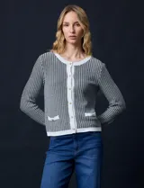 Cardigan de tejido tweed celeste y blanco, con escote redondo, cierre frontal con botones metálicos dorados y bolsillos simulados en el frente.