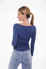 Remera de mangas largas color celeste, con cuello redondo y terminaciones con volados.