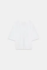 Camiseta blanca de manga corta amplia y escote en V, con corte regular fit.