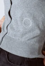 Cárdigan gris de punto con cuello redondo y cierre frontal con botones.