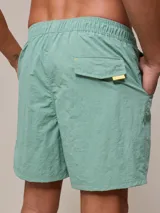 Short de baño azul marino con cintura elástica ajustable con cordón y logo de la marca bordado en rojo en la pierna izquierda.