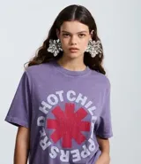 Remera de algodón color lila con estampado frontal del logo de la banda Red Hot Chili Peppers en rojo y blanco. Tiene cuello redondo y mangas cortas.