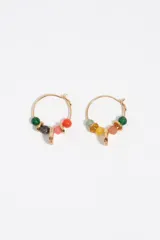 Caravanas tipo argolla dorada decoradas con cuentas de piedras de colores y un dije colgante cilíndrico con inscripciones.