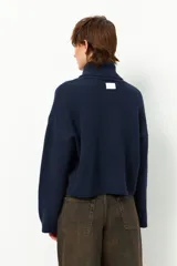 Polera color beige de poliéster reciclado, de cuello alto y manga larga.