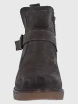 Bota corta de descarne color marrón oscuro, con diseño de caña media y cierre lateral. Presenta una tira decorativa con hebilla metálica en el tobillo y suela de goma tipo plataforma con textura rugosa.