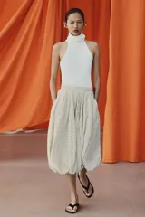 Falda midi de tiro medio color beige con estampado de cuadros finos oscuros. Presenta pliegues en la cintura y bajo abullonado con acabado evasé, de Zara Woman Collection.