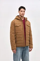 Campera de gabardina capitoneada con interior forrado en nylon. Presenta capucha fija, bolsillos frontales en el pecho con solapa y bolsillos laterales con cierre. Cuenta con cierre frontal central.