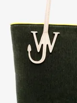 Bolso tipo tote de chenilla color verde oscuro con ribete amarillo. Tiene dos correas de hombro color crema, compartimento principal con bolsillos internos y apliques metálicos con el logo de la marca.