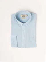 Camisa celeste de lino, de manga larga, con cuello abotonado y bolsillo en el pecho.