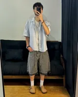 Bermuda de jean gris con efecto lavado, corte amplio, cordón ajustable en la cintura y terminación desflecada.