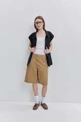 Bermuda de algodón color tostado, de calce amplio y largo a la rodilla, con bolsillos utilitarios delanteros y cierre frontal.