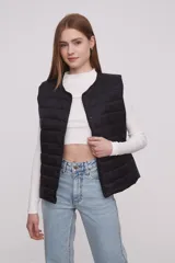 Chaleco acolchado color verde militar con cierre de botones a presión.