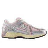 Championes New Balance modelo 1906, con diseño técnico en tonos rosa y detalles metalizados plateados. Presenta una estructura de malla transpirable, refuerzos sintéticos y entresuela con tecnología de amortiguación en color crema.