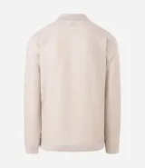 Polo de manga larga color beige claro, confeccionado en tejido texturizado (posiblemente acanalado o waffle). Presenta un cuello polo con escote profundo en V sin botones.