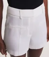 Bermuda femenina de sastrería color rojo, confeccionada en tejido de crepé. Presenta trabillas en la cintura, cierre delantero y bolsillos falsos.