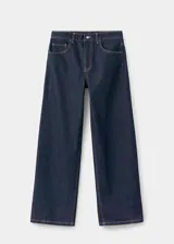 Pantalón de jean estilo barrel con diseño balloon, de tiro medio y corte holgado. Presenta cinco bolsillos, cierre frontal con cremallera y botón, y costuras en contraste.