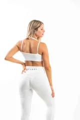 Top deportivo azul con breteles cruzados en la espalda y logo en el frente.