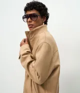 Campera tipo bomber de tacto gamuzado, con cuello alto, cierre frontal con botones a presión, bolsillos laterales y puños ajustables con botón.