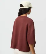 Remera de modal color crudo, con diseño minimalista, calce amplio, cuello redondo y mangas cortas amplias con hombros caídos.