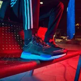 Championes Adidas NMD_V3 negros con detalles en azul y suela Boost blanca.