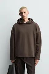 Sudadera tipo hoodie de corte relajado, confeccionada en tejido de algodón con interior de rizo. Presenta cuello con capucha, manga larga y acabados con bordes enrollados.