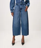 Pantalón de jean estilo barrel con tiro alto, recortes laterales sastreros y diseño amplio en las piernas. Confeccionado en algodón con lavado medio.