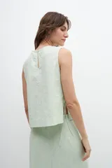 Musculosa verde manzana de lino con breteles finos y lazos laterales.