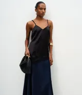 Pollera midi de satén color negro, con corte evasé y cintura elástica. Presenta una caída fluida y suave con acabado brillante.