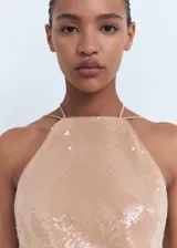 Vestido midi de lentejuelas color tostado, sin mangas, con cuello halter, tirantes finos ajustables con lazo en el cuello y diseño recto.