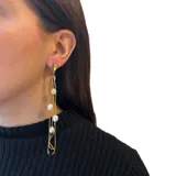 Aros colgantes dorados con perlas de río y cadenas finitas.