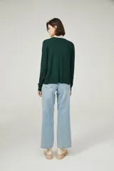 Cárdigan color beige con escote en V y cierre frontal con botones.