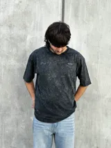 Remera oversize gris con efecto lavado y estampado en la espalda con la frase "STORIES OF THE EAST".