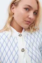 Cardigan de punto con diseño de rombos en color celeste sobre fondo blanco, cuello redondo y cierre frontal con botones.