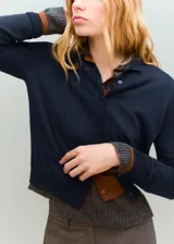 Cardigan de punto fino azul marino, confeccionado en mezcla de algodón y lana, de corte recto con cuello redondo, manga larga y cierre frontal de botones.